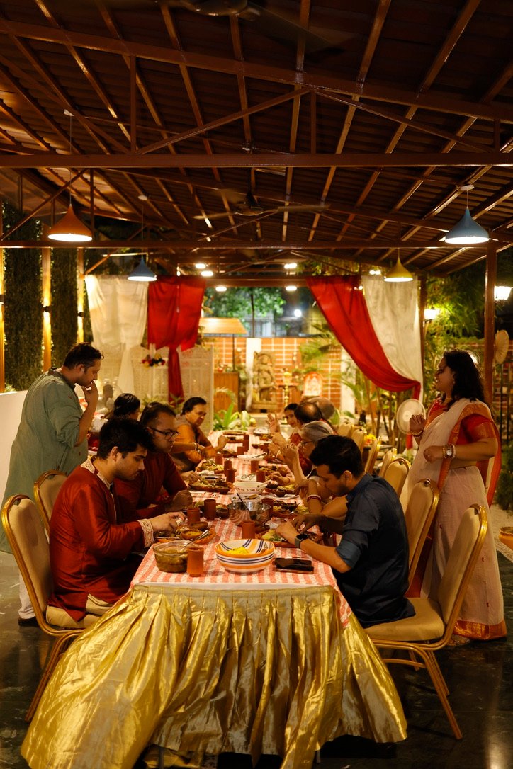 Poila Baisakh dinner — guests at the long table under warm lights